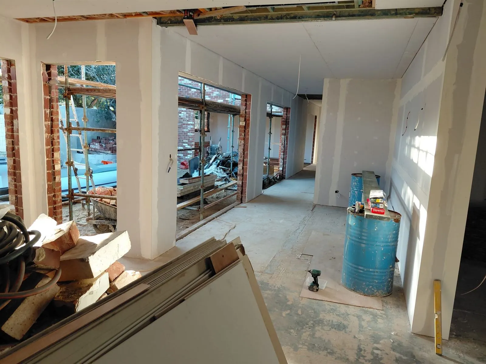Open-plan area with the walls sheeted and joints set, scaffold outside the openings