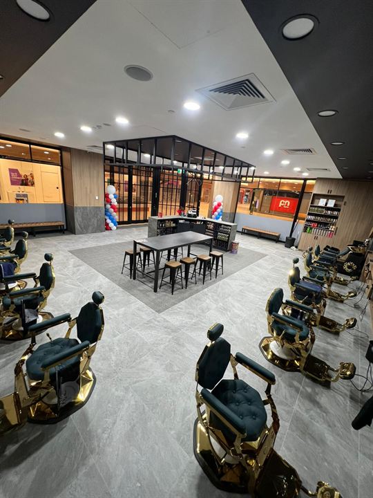 Barber shop floor in grey large-format tiles with darker inset areas