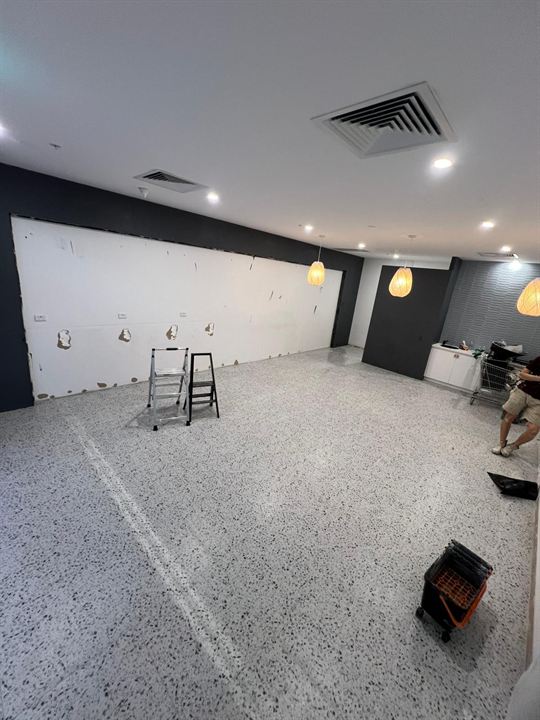 Empty shop with the old terrazzo floor, before tiling
