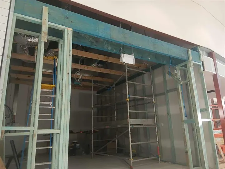 Steel-stud shopfront and ceiling framing in an empty shop unit