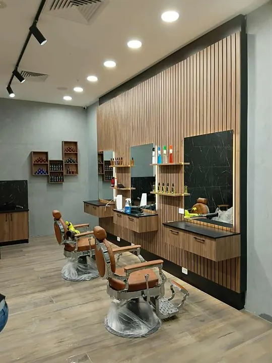 Finished barber stations against a timber batten wall, timber-look tiled floor