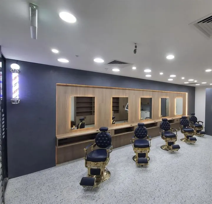 White terrazzo-look floor under a row of barber stations