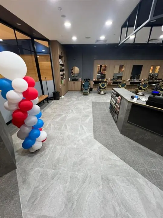 Finished barber shop with a grey stone-look floor and the service counter
