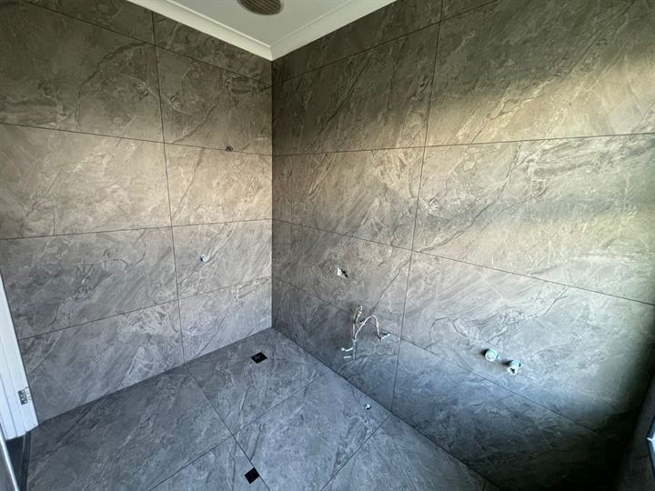 Walk-in shower with full-height dark wall tiles