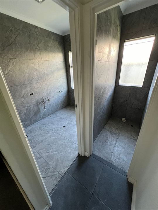 Bathroom and toilet tiled in dark stone-look tiles