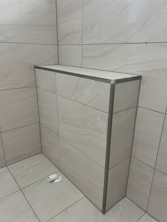 Tiled half-wall finished with an aluminium edge trim