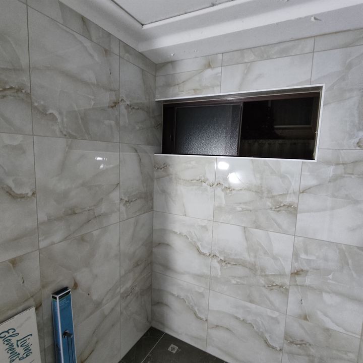 Veined wall tiles wrapped into a window reveal