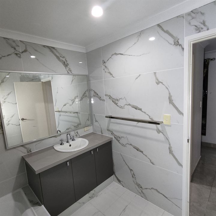 Vanity wall in white marble-look tiles