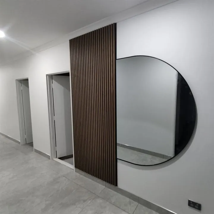 Timber batten panel on a hallway wall beside a round mirror