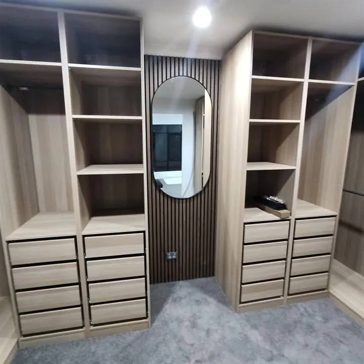 Walk-in robe with open shelving, drawers and a batten panel behind an oval mirror