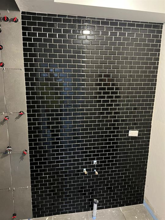 Feature wall in black subway tiles