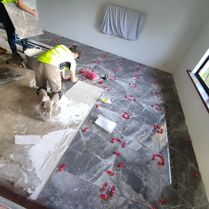Laying a dark marble-look floor with levelling clips on every joint