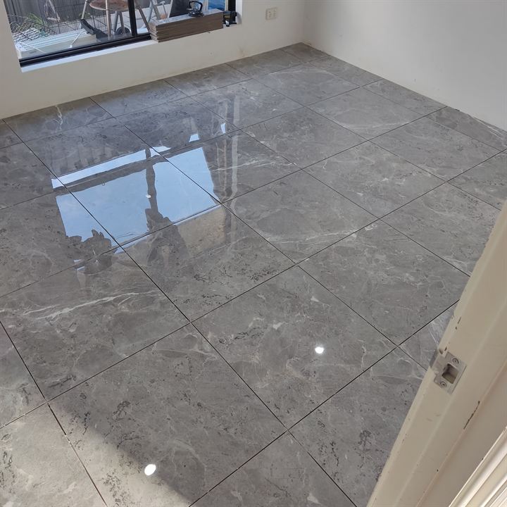 Bedroom floor in polished dark grey marble-look tiles