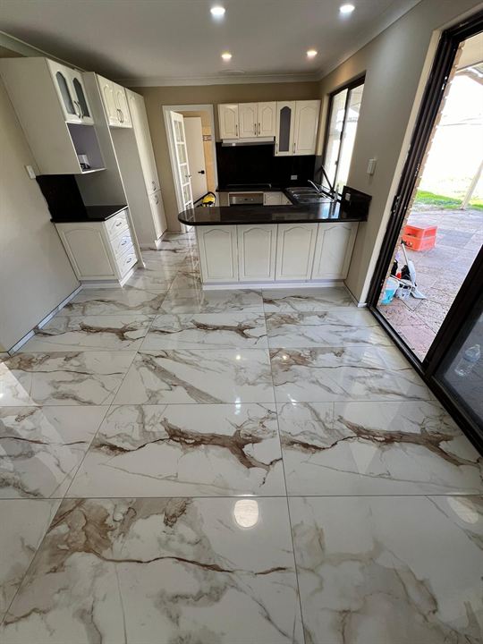 Gold-veined marble-look floor tiles through a kitchen and living area