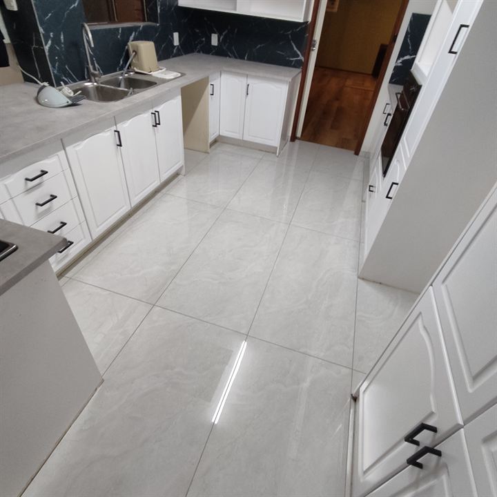 Polished grey floor tiles through a kitchen