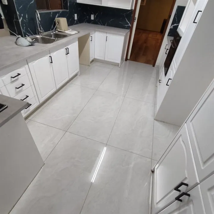 Polished grey floor tiles through a kitchen