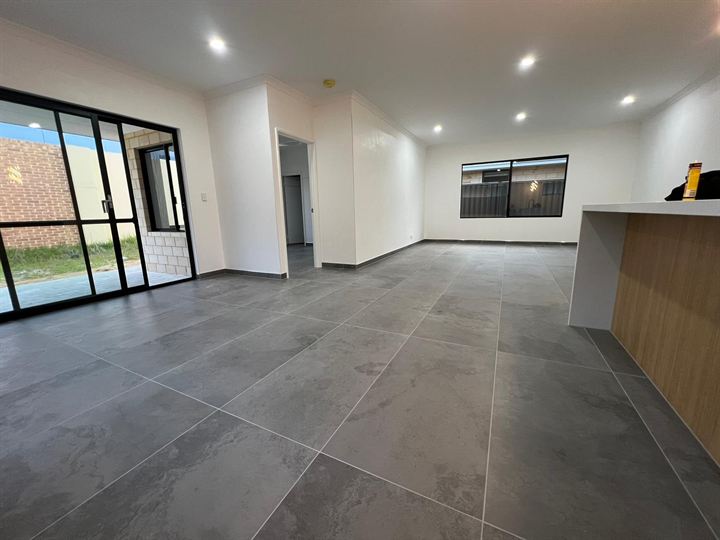 Grey large-format floor tiles through an open-plan living area