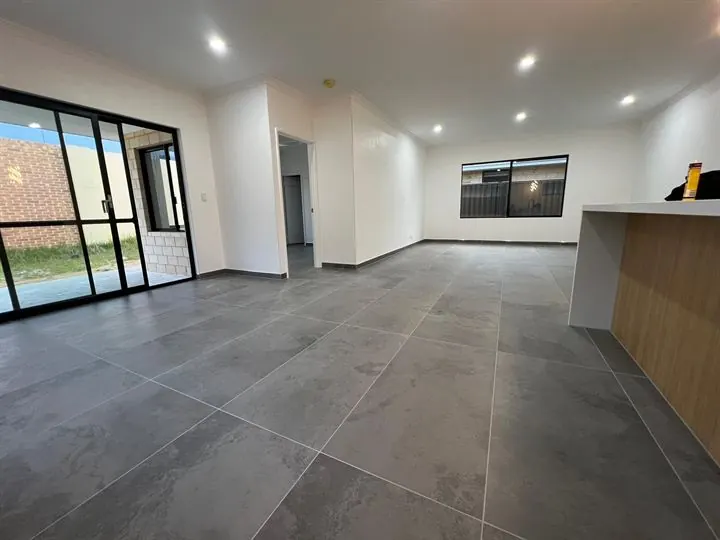 Grey large-format floor tiles through an open-plan living area
