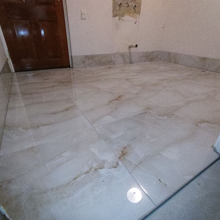 Room floor in veined marble-look tiles with tiled skirting
