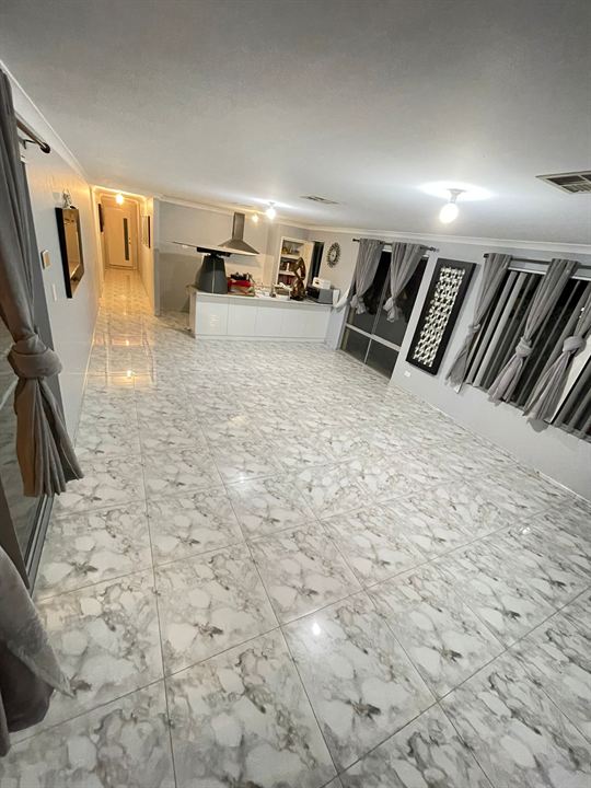 White marble-look floor tiles through a living room and kitchen