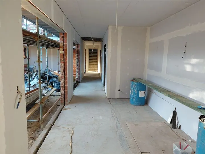 Hallway with plasterboard joints flushed, stairs at the far end