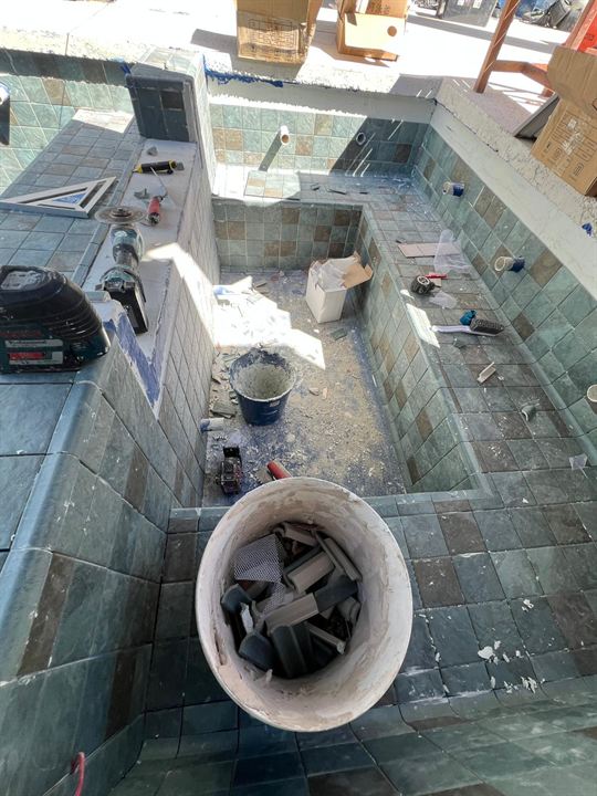 Pool steps and bench being tiled