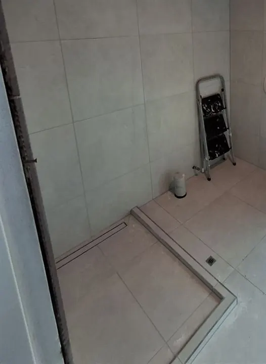 Shower floor tiled to a strip drain